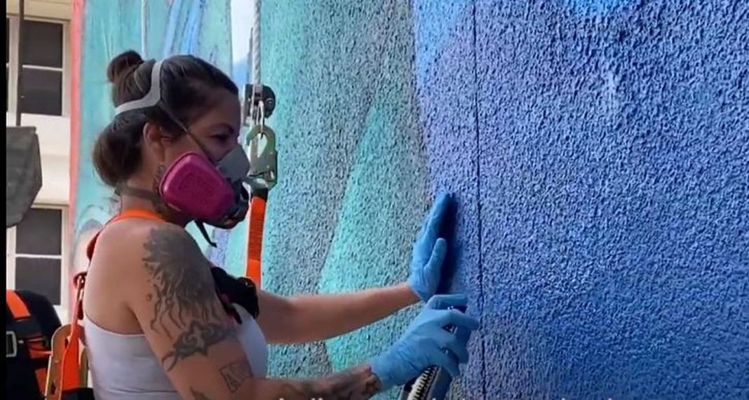 Claudia La Bianca mentre dipinge la facciata del Jackson Memorial Hospital