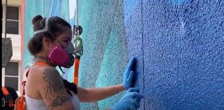 Claudia La Bianca mentre dipinge la facciata del Jackson Memorial Hospital