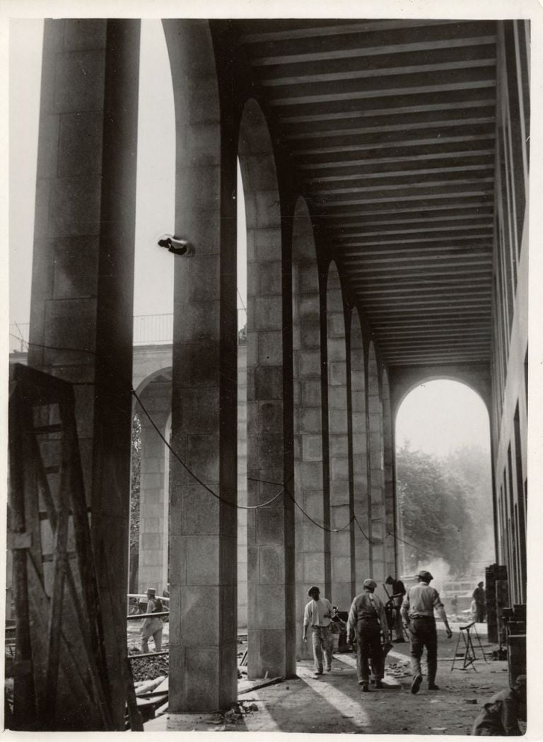 Operai al lavoro sotto il portico sul fronte est del Palazzo dell'Arte durante i lavori di costruzione. Photo Argo. Courtesy © Triennale Milano Archivi