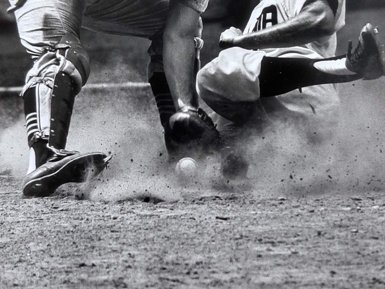 An amazing detail photograph of a close baseball play