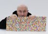 Damien Hirst with The Currency artworks, 2021. Photographed by Prudence Cuming Associates Ltd © Damien Hirst and Science Ltd, DACS 2021