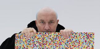 Damien Hirst with The Currency artworks, 2021. Photographed by Prudence Cuming Associates Ltd © Damien Hirst and Science Ltd, DACS 2021