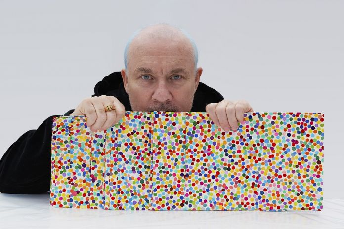 Damien Hirst with The Currency artworks, 2021. Photographed by Prudence Cuming Associates Ltd © Damien Hirst and Science Ltd, DACS 2021