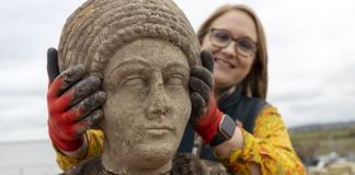 L’archeologa Rachel Wood posa con la statua femminile ritrovata. Photo HS2