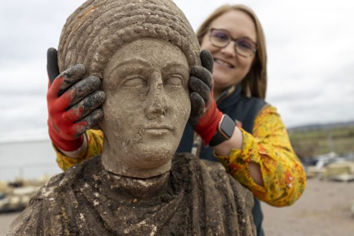 L’archeologa Rachel Wood posa con la statua femminile ritrovata. Photo HS2