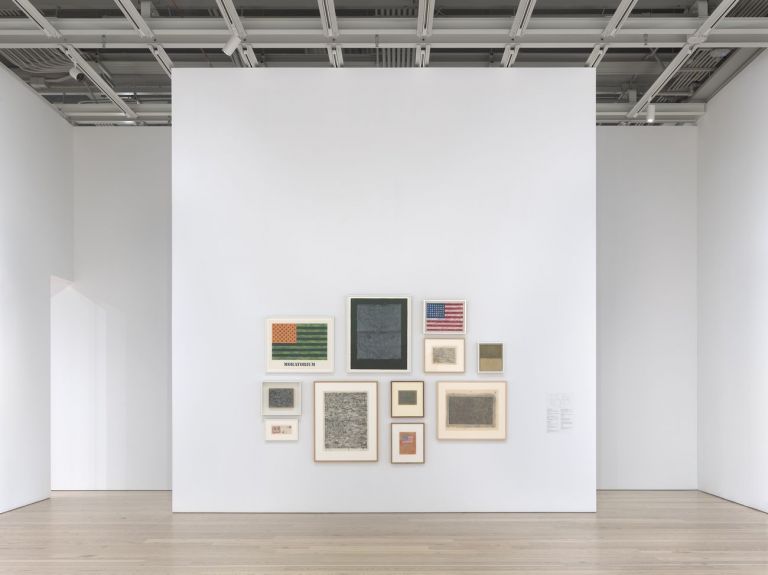 Installation view of Jasper Johns: Mind/Mirror (Whitney Museum of American Art, New York, September 29, 2021-February 13, 2022). Clockwise, from top left: Moratorium, 1969; Two Maps I, 1966; Flag, 1957; Flag, 1958; Green Map above White, 1966-67; Map, 1965; Flag on Orange Field, 1957; Green Flag, 1956; Two Flags, 1960; Untitled (Envelope), 1959; Map, 1960. Photograph by Ron Amstutz