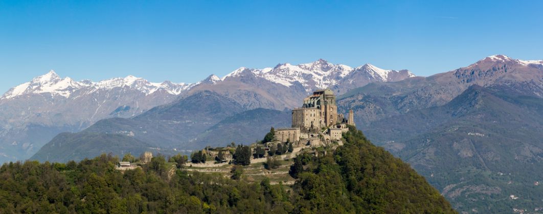 The Sacra di San Michele (Saint Michael Abbey) , the symbol of the Italian region of Piedmont, In the background the mountains of the Val di Susa. Panorama view