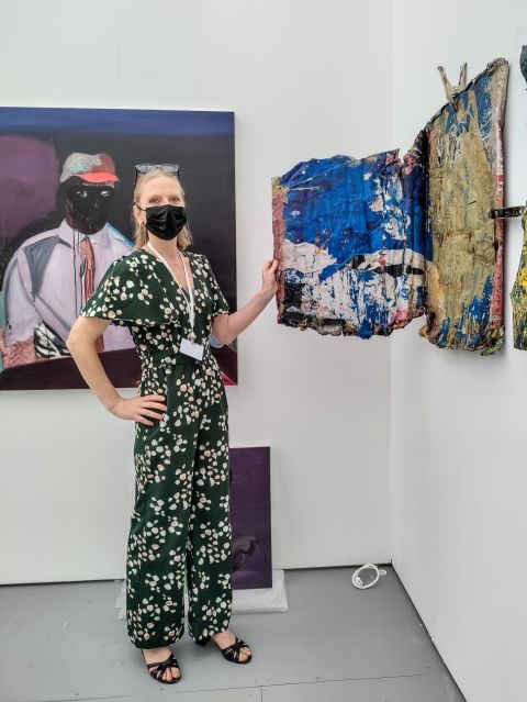 Sarah Corona mostra una delle opere di Osaretin Ugiagbe esposte nello stand di Sarah Crown a Untitled Miami Beach 2021. Photo: Maurita Cardone