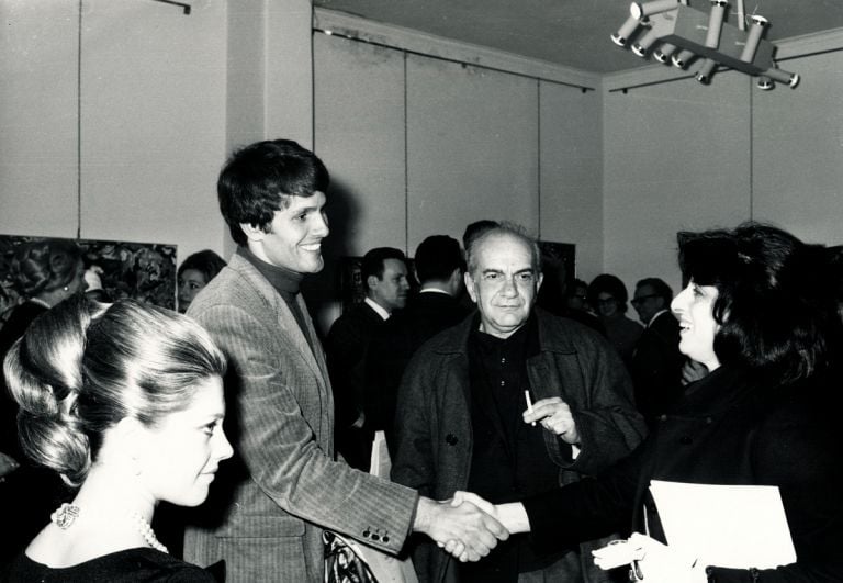Giuliano Gemma e Anna Magnani si stringono la mano alla inaugurazione della mostra di Carlo Levi; tra i presenti, Simona Marchini e Corrado Cagli, 22 febbraio 1968