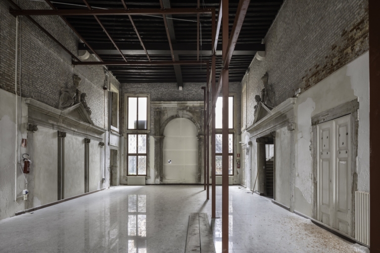 Entrance hall with portals connecting to the waterfront and the main staircase to the first floor, adorned with Ionic columns, entablature with inclined bands and central tympanum in Istrian stone, surmounted by sculptures in plaster and wood. Ph. ©Alessandra Chemollo, courtesy of Berggruen Arts & Culture