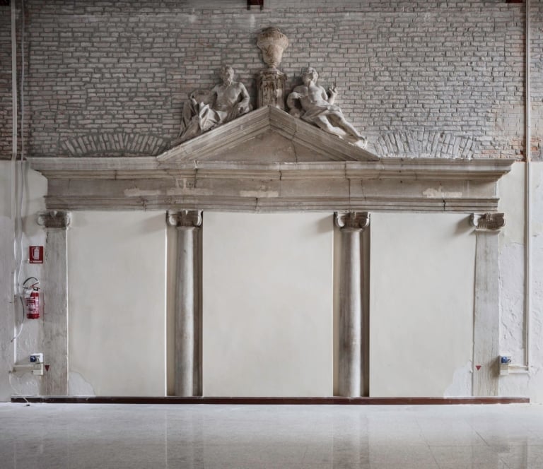 Portal connecting to the lateral waterfront, adorned with Ionic columns, entablature with inclined bands and central tympanum in Istrian stone, surmounted by sculptures in plaster and wood. Ph. ©Alessandra Chemollo, courtesy of Berggruen Arts & Culture