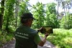 Una guida mostra la riproduzione di un'opera nel luogo dove fu dipinta, Foresta di Fontainebleau presso Barbizon, Francia. Photo © Dario Bragaglia