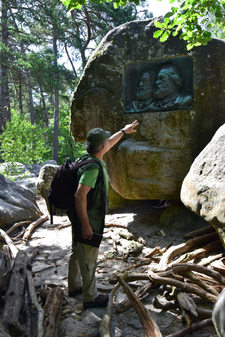 Una guida della foresta davanti alla placca commemorativa che ricorda Théodore Rousseau e Jean François Millet, Foresta di Fontainebleau presso Barbizon, Francia. Photo © Dario Bragaglia