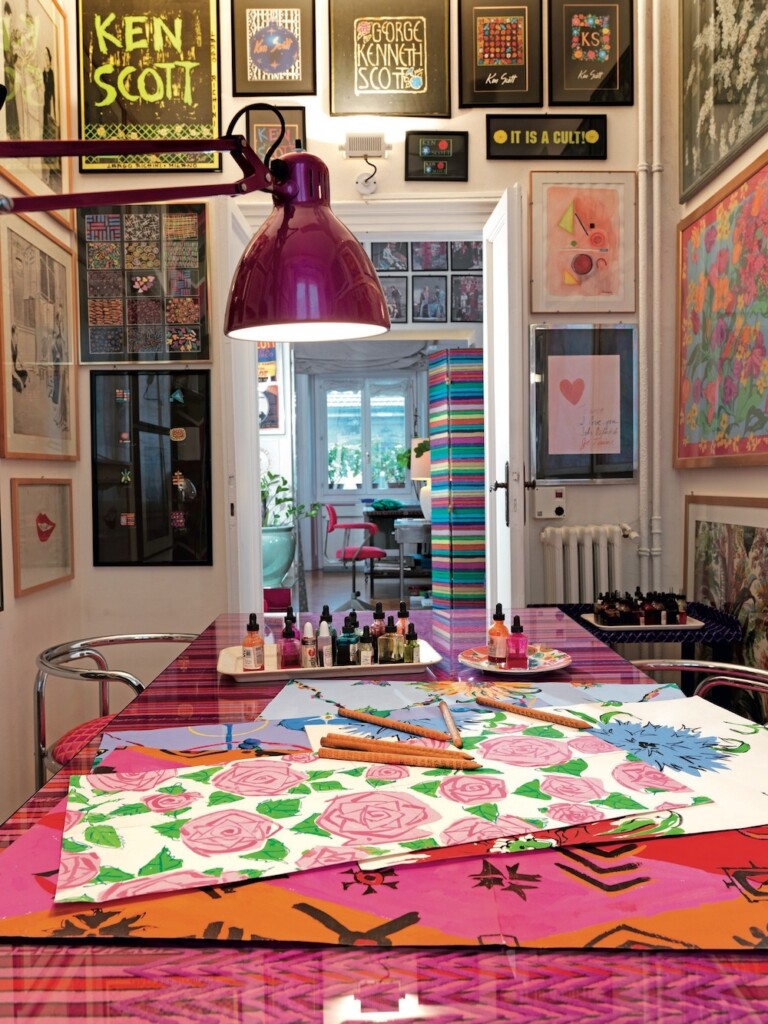 The meeting room in Ken Scott’s studio on Via Besana 1, Milan: Gae Aulenti tubular armchairs upholstered with Domino print (1971); table top featuring embroidered Righit print (1975); striped folding screen with the Istrisc print (1966); sketches, studies, and foulards on the table and walls. Photo by Ruy Teixeira for Velvet, 2010. © Ruy Teixeira