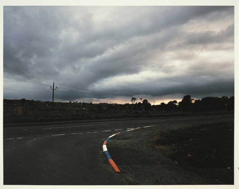 Paul Graham, Unionist Coloured Kerbstones at Dusk, Near omagh, 1985. Courtesy Fondazione Sandretto Re Rebaudengo, Torino