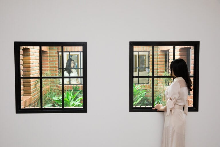 Leandro Erlich, Lost garden (2009), Metal structure, bricklike wall, windows, mirrors, acrylic, column, artificial plants, and lights, 257x356x180 cm