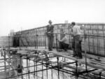 Enrico Pasquali, Il Direttore dei lavori, ingegnere Ugo Chiodarelli, e operai al lavoro alla realizzazione dei portali all’impianto del Palantone, 1965. Archivio CER