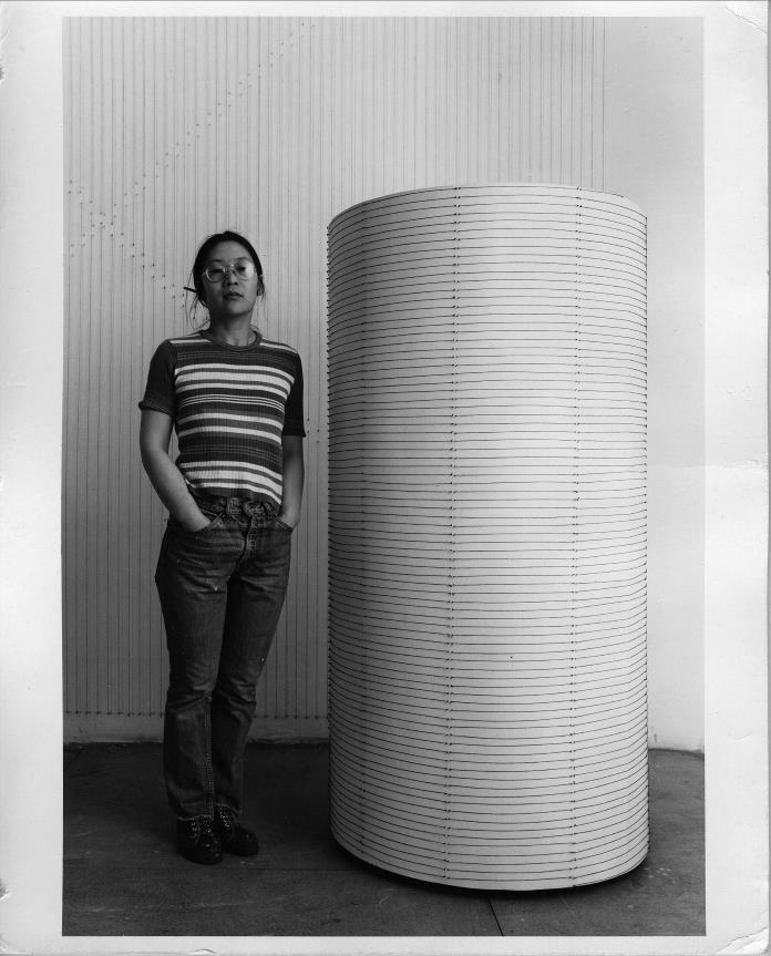 Kazuko Miyamoto accanto a standing by String around a cylinder of my height, 1977, Courtesy: l’artista, EXILE Take Ninagawa, Tokyo © Kazuko Miyamoto