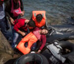 Ivor Prickett. Susan, rifugiata siriana di trentacinque anni originaria di Aleppo, sviene a causa del mal di mare e della fatica dopo aver attraversato l’Egeo dalla Turchia a Lesbo con il marito e i tre bambini. 2015, Lesbo, Grecia. Fotografia dalla serie "Seeking Shelter. Part II - West". Courtesy and © Ivor Prickett
