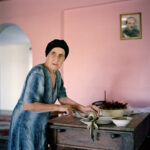 Ivor Prickett. La madre di Tengo Inalishvili prepara una pasta piccante di peperoncini secchi nella casa della famiglia Inlaishvili nel villaggio di Rechxi. 2010, Rechxi, Abkhazia. Fotografia dalla serie "Returning Home - Abkhazia". Courtesy and © Ivor Prickett