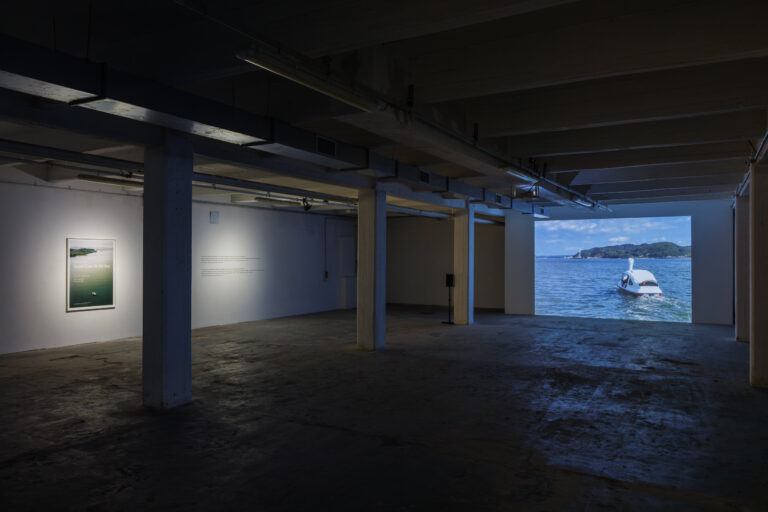 Shimabuku, Swan Goes to the Sea, 2012-2014, video, poster, testo in vinile sul muro, installation view at ZERO..., Milano, 2023