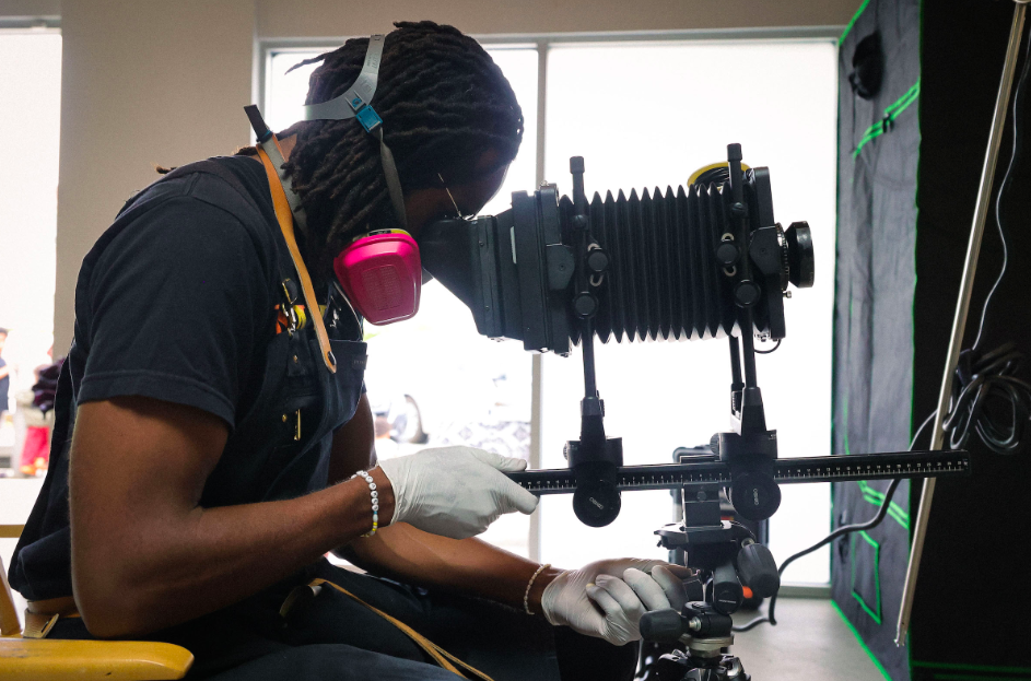 Il fotografo Adam Davis mostra il processo fotografico della tipografia durante l'inaugurazione del Black Image Center nel 2022. Copyright: Black Image Center
