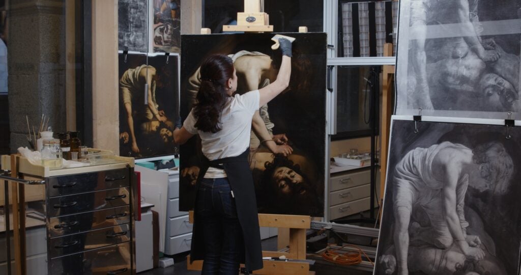 Almudena Sánchez nei laoboratori del Museo del Prado mentre restaura l'opera di Caravaggio