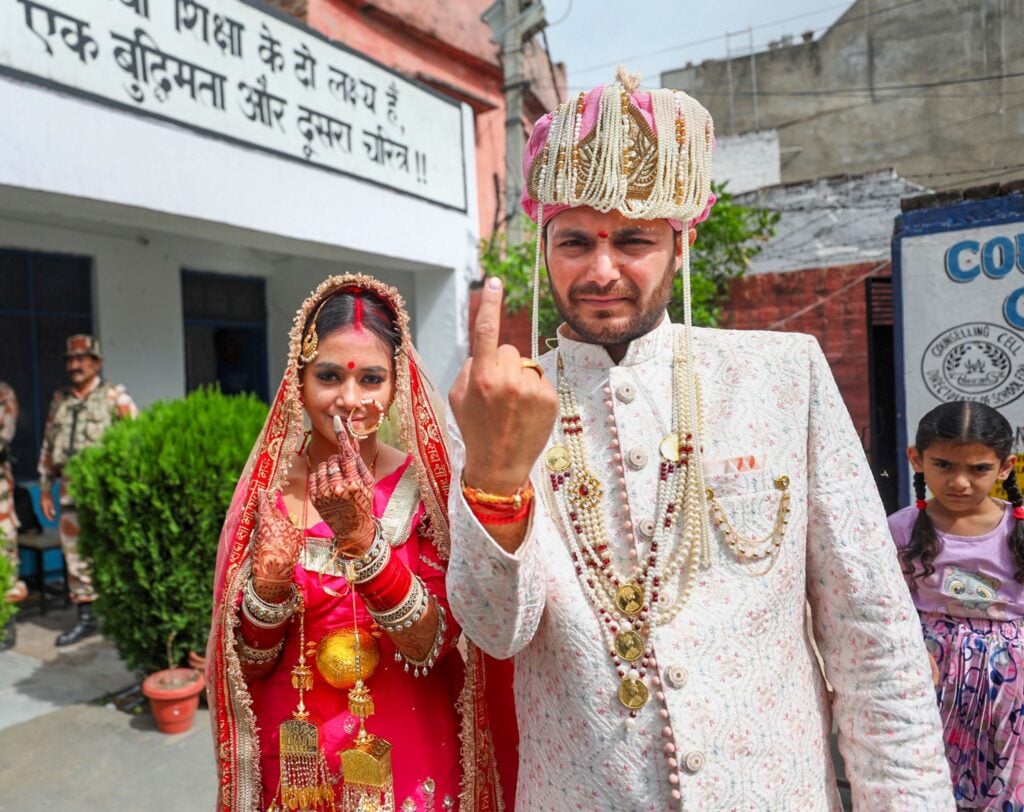 Una coppia di sposi mostra il dito marchiato con l'inchiostro dopo il voto nel distretto di Kathua. Photo PTI