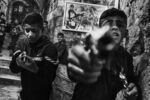 Nablus, Territori Palestinesi, 13/3/2024. Bambini giocano con pistole giocattolo davanti alla casa di Wadi al-Hawah, fondatore del gruppo militante palestinese La Tana dei Leoni nella città vecchia di Nablus. Wadi è stato ucciso durante un raid israeliano nell'ottobre 2022 ed è considerato uno degli eroi locali della resistenza. Photo Lorenzo Tugnoli