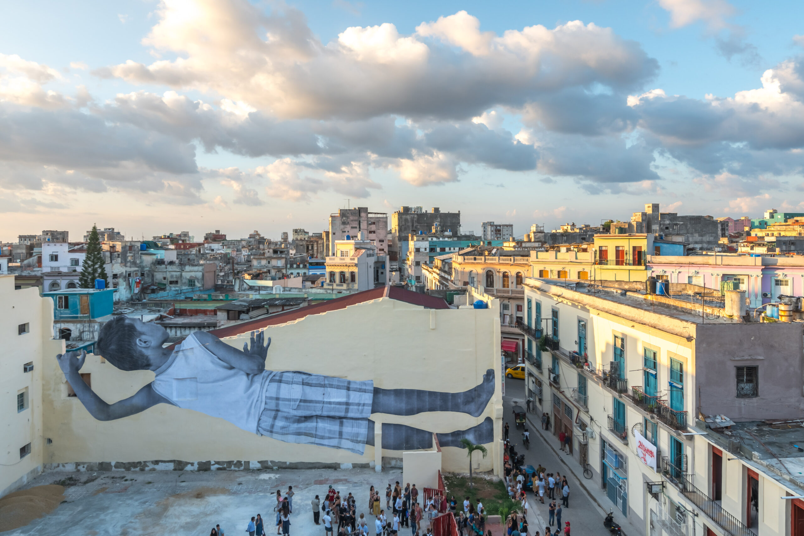 https://www.artribune.com/wp-content/uploads/2025/05/7-jr-giants-peeking-at-the-city-havana-cuba-2019-scaled.jpg