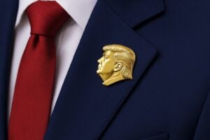 Quella con il profilo di Trump non è solo una spilla. È uno strumento di potere