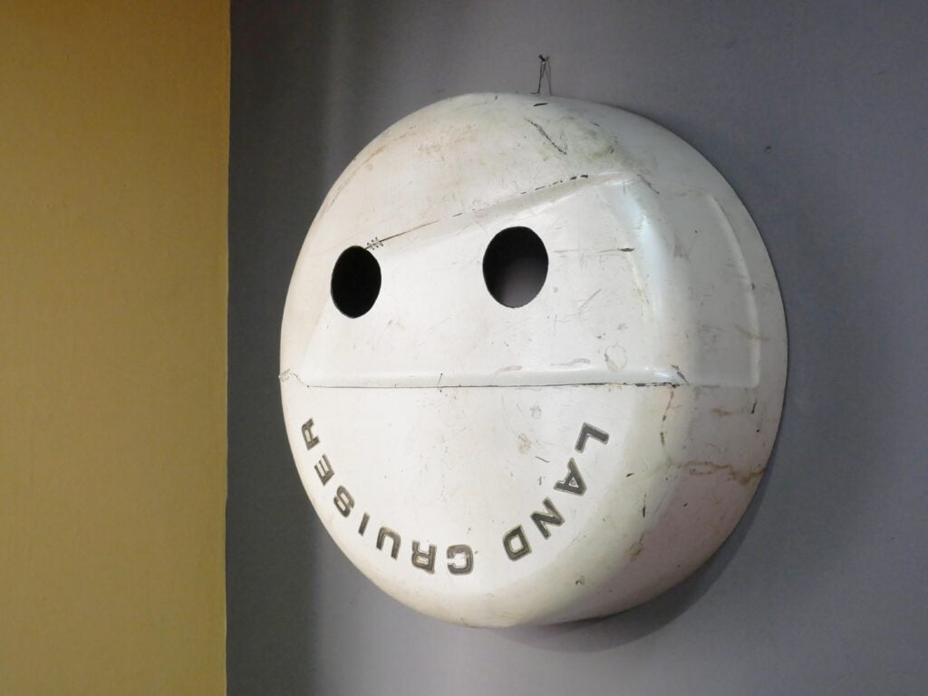Nero/Alessandro Neretti, LAND CRUISER (sourire), 2024 , objet trouvé modificato (copriruota di jeep), 86 x 86 x 32 cm. Courtesy dell’artista
