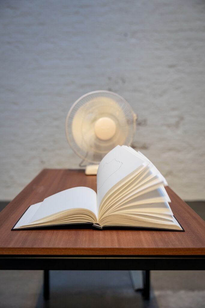 Shilpa Gupta, 100 Hand drawn Maps of Germany, 2025, Tavolo, ventilatore, Libro, 106.7x61x147 cm, installation view, Courtesy neugerriemschneider, &copy; Shilpa Gupta. Foto: Andr&eacute; Leisner