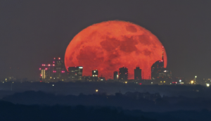 Il fotografo Valerio Minato colpisce ancora. Lo straordinario scatto della luna rossa allineata con lo skyline di Milano: “ho atteso per 5 anni”