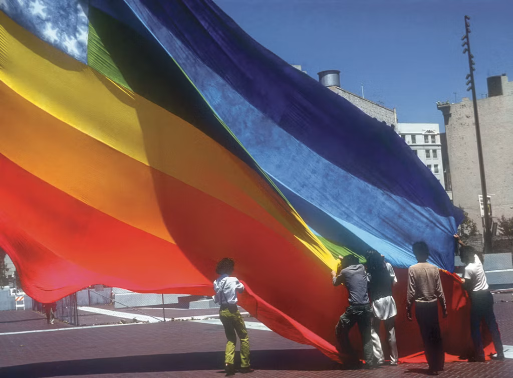 Gilbert Baker e i volontari coinvolti in una delle prime apparizioni della bandiera arcobaleno nel 1978. Photo James McNamara. Courtesy Mick Hicks