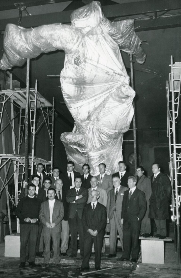 Francesco Somaini con le maestranze locali davanti al modello in creta del Monumento ai Marinai rassegna per Francesco Somaini ad&rsquo;ItaliaMilano, Lomazzo, 1966. Courtesy Archivio Francesco Somaini