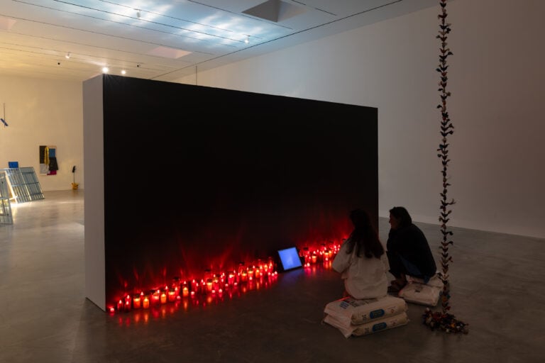 Bruna Esposito, Oltremare (sotto terra vulnerabili), 2006-2011. Video in loop con audio, monitor, sacchetti di riso, lumini da cimitero, rame, seta. Courtesy Wizard Gallery, Milano. Courtesy della foto: Magazzino Italian Art, foto di Marco Anelli e Tommaso Sacconi.