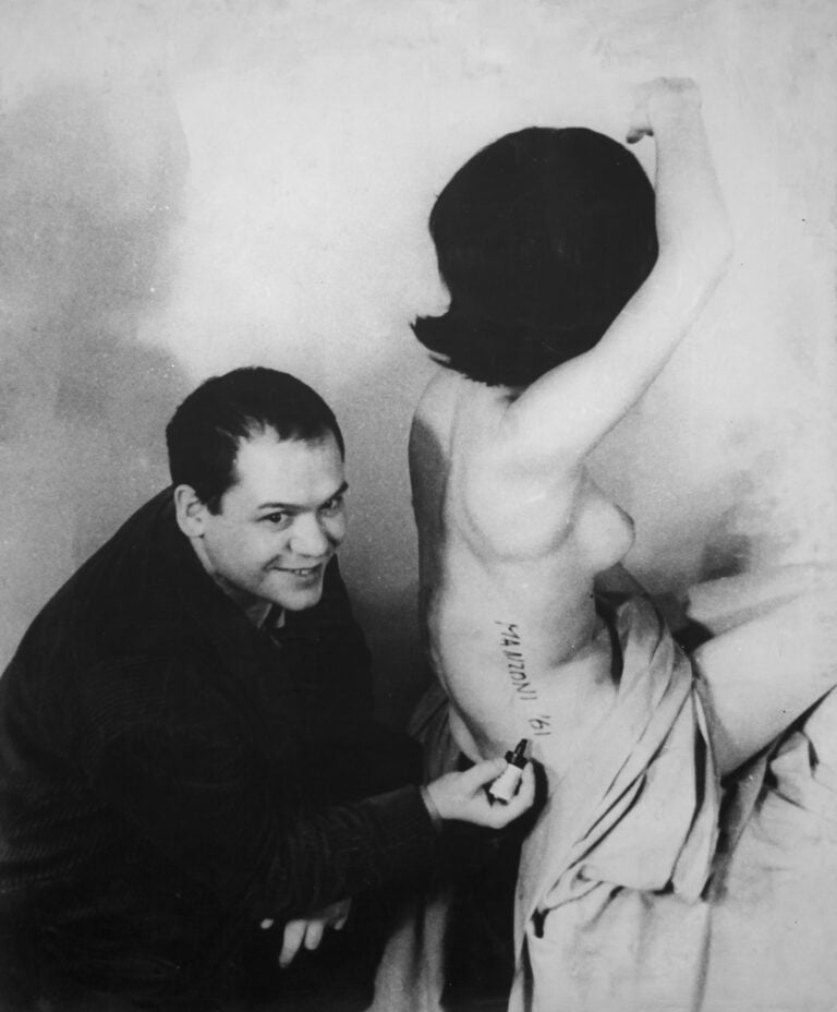 Piero Manzoni Piero Manzoni mentre firma una Scultura vivente Milano, 1961 ph. Giuseppe Bellone &copy; Fondazione Piero Manzoni, Milano