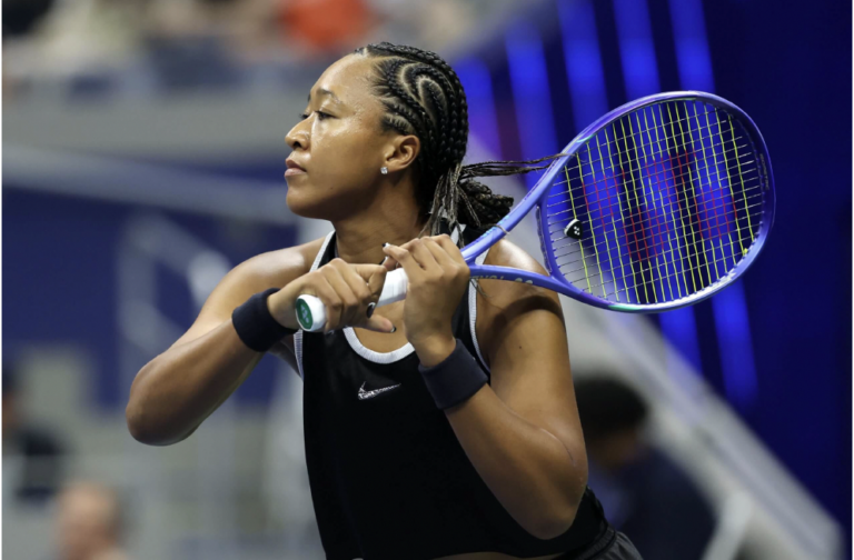 Naomi Osaka in azione mentre esegue un rovescio a due mani indossando una canotta senza maniche agli US Open 2026