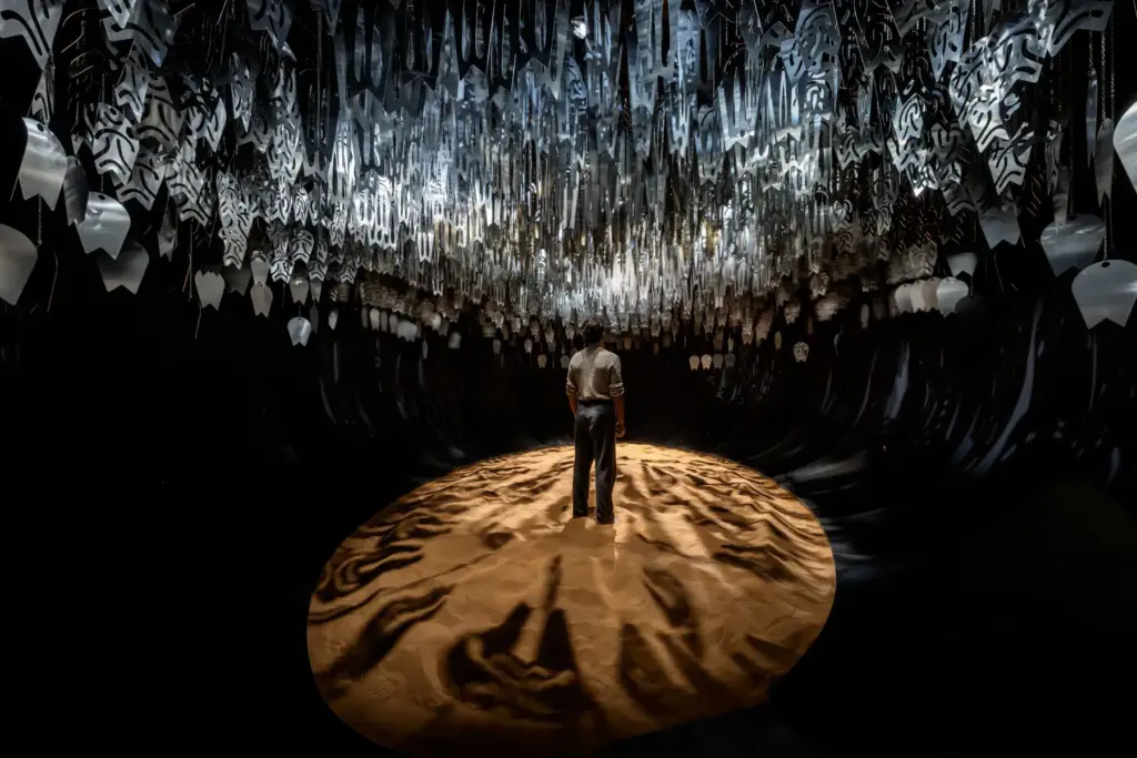 Nel Padiglione Oman alla Biennale i visitatori camminano sulla sabbia sotto una costellazione d’argento. L’intervista 