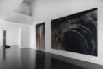 Veduta parziale della mostra di Helmut Schober Luce e movimento, Foto &copy; Fabio Mantegna, courtesy Fondazione Mudima. A sx Concerto I (scultura in ottone nichelato e 5 sequenze fotografiche della scultura fissata al corpo), 1975-1977, Performance presentata a Documenta 6, 1977, Al centro Figura con idolo, 1985, Grafite e acrilico su tela, 320 x 210 cm, Biennale di Venezia - Arte e scienza, 1986, A dx Campo di battaglia 1, 1985 grafite e acrilico su tela, 300 x 400 cm, Documenta 8, Kassel, 1987