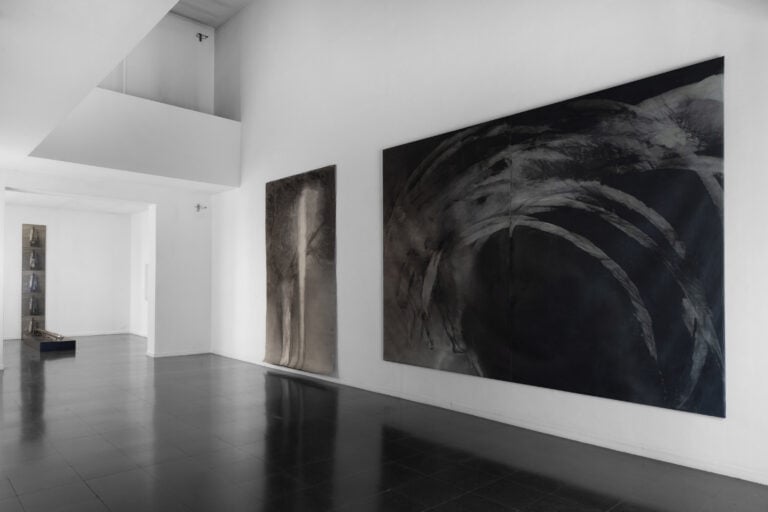 Veduta parziale della mostra di Helmut Schober Luce e movimento, Foto &copy; Fabio Mantegna, courtesy Fondazione Mudima. A sx Concerto I (scultura in ottone nichelato e 5 sequenze fotografiche della scultura fissata al corpo), 1975-1977, Performance presentata a Documenta 6, 1977, Al centro Figura con idolo, 1985, Grafite e acrilico su tela, 320 x 210 cm, Biennale di Venezia - Arte e scienza, 1986, A dx Campo di battaglia 1, 1985 grafite e acrilico su tela, 300 x 400 cm, Documenta 8, Kassel, 1987