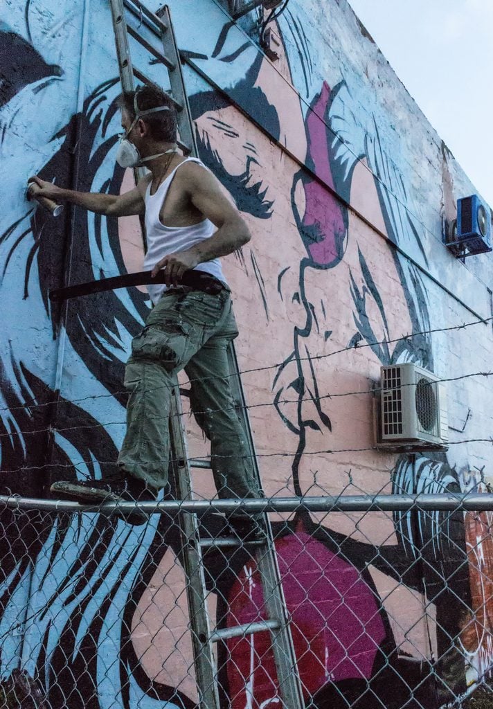 Stephen Bliss al lavoro sul murales "The Kissing". Ph: Sean Ryan